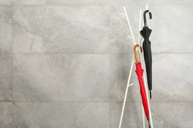 Gri mermer duvarın yanındaki raflarda renkli şemsiyeler, metin için boşluk