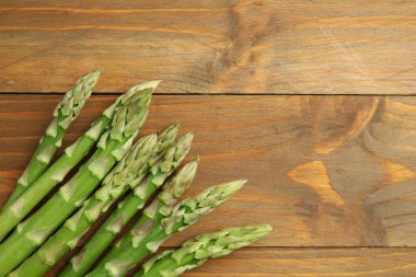 Taze yeşil kuşkonmaz, ahşap masa üzerinde, üst manzara. Metin için boşluk