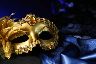 Mavi kumaşlı güzel altın karnaval maskesi Karanlıkta, yakın plan