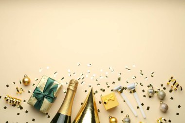 Düz kompozisyon konfeti ve bej arka planda bir şişe köpüklü şarap, mesaj için boşluk. Noel dekoru