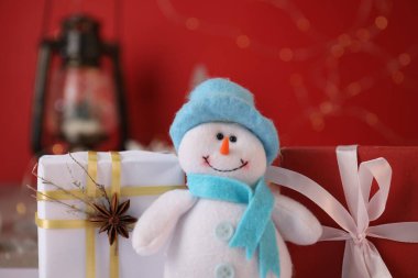 Komik kardan adam figürü ve Noel hediyeleri masada, yakın plan.