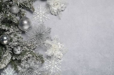 Gri desenli arkaplan üzerinde Noel dekoru olan düz bir kompozisyon, metin için boşluk