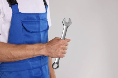 Açık gri arka planda ingiliz anahtarı olan oto tamircisi, yakın plan. Metin için boşluk