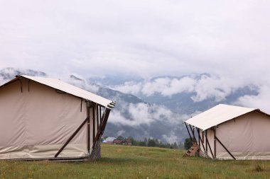 Dağlarla kaplı çadır ve orman. Glamping alanı