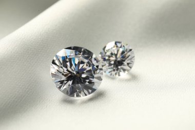 Beyaz kumaş üzerinde iki güzel pırlanta, yakın plan.