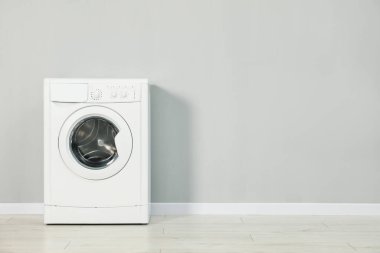 Gri duvarın yanında çamaşır makinesi, metin için boşluk