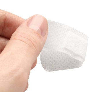 Kadın, beyaz arka plana tıbbi yapıştırıcı bandaj yapıştırıyor. Yakın plan.