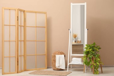 Banyoda bej duvarın yanında büyük bir ayna var. İç tasarım