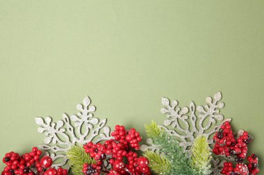 Köknar ağacı dalları ve yeşil arka planda Noel dekoru olan düz bir kompozisyon. Metin için boşluk