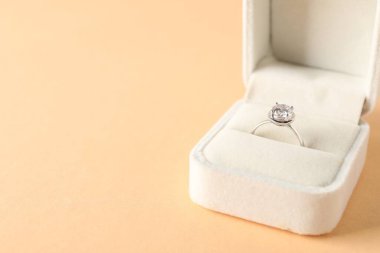 Bej arka planda değerli taşlı güzel bir yüzük, yakın plan. Metin için boşluk