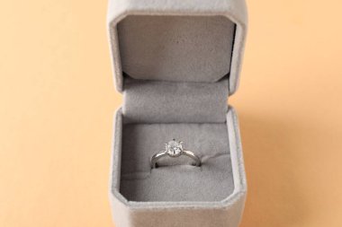 Bej arkaplanda değerli taşlı güzel bir yüzük, yakın plan.