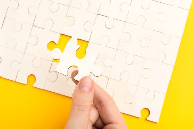 Sarı arka planda beyaz bulmacayı çözen kadın, yakın plan