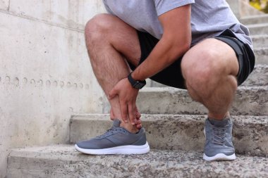 Basamaklarda ayak ağrısından muzdarip bir adam, yakın plan