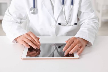 Klinikteki masada tabletli doktor, yakın çekim.