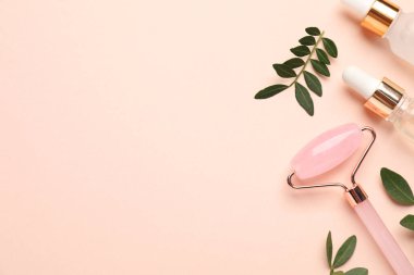 Farklı kozmetik ürünleri ve bej arka planda yeşil yapraklar. Metin için boşluk