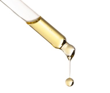 Temel yağ beyaz arka planda pipetten damlıyor