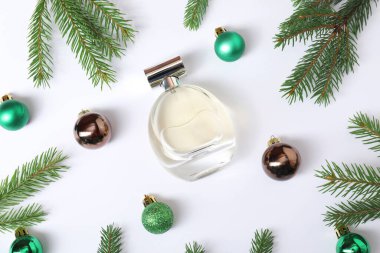 Beyaz arka planda parfüm şişesi olan Noel kompozisyonu.
