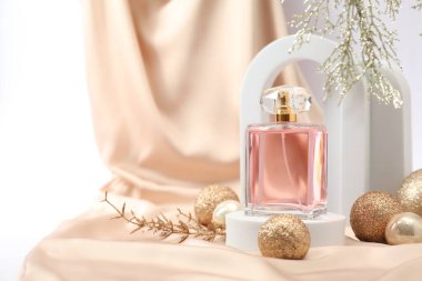 Beyaz arka planda parfüm şişesi ve Noel dekorunun şık kompozisyonu. Metin için boşluk