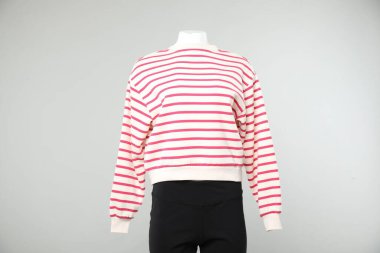 Hafif arka planda şık giyimli bir kadın mankeni.