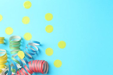 Açık mavi arka planda parti flamaları ve konfeti düz yerde. Metin için boşluk