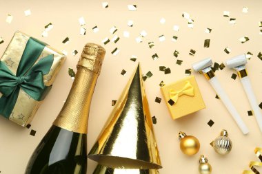 Düz kompozisyon, konfeti ve bej arka planda bir şişe köpüklü şarap. Noel dekoru