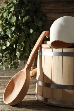Sauna ekipmanları. Kova, ahşap yüzeyde yün şapka ve kepçe