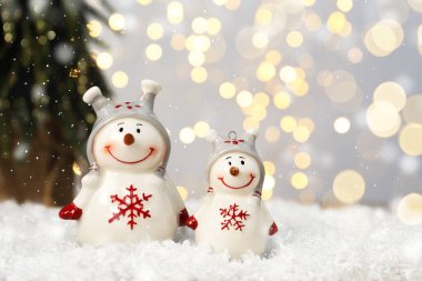 Bulanık Noel ışıklarına karşı sevimli kardan adam figürleri, mesaj için yer. Bokeh etkisi