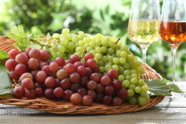 Taze üzümler ve tahta masada bir kadeh şarap.