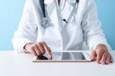 Tabletli doktor açık mavi arkaplanda, yakın görünüm