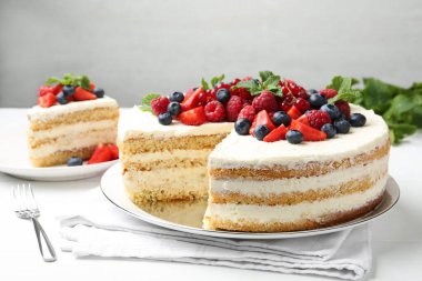 Taze böğürtlenli ve beyaz masada servis edilen lezzetli sünger keki.