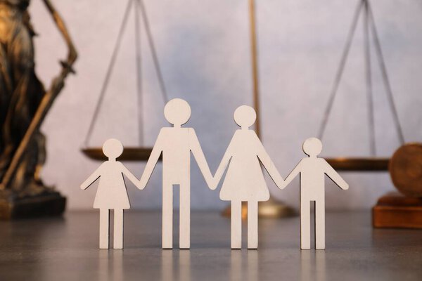 Алименты. Фигуры семьи на сером столе, крупный план