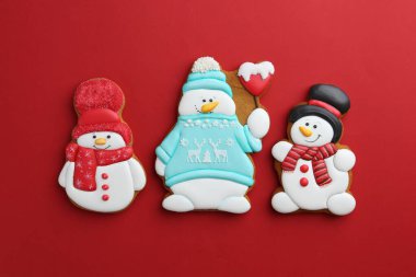Kırmızı arka planda kardan adam şeklinde lezzetli Noel kurabiyeleri.