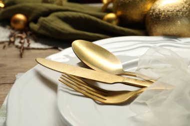 Tabaklar, çatal bıçak takımı ve Noel dekorasyonu masada, yakın plan.