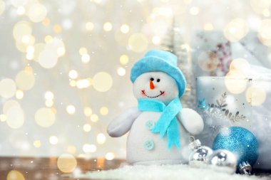 Tatlı kardan adam ve bulanık arka plana karşı Noel topları, bokeh etkisi. Metin için boşluk