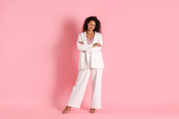 Красивая женщина в стильном костюме на розовом фоне
