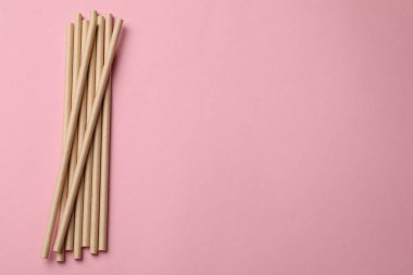 Pembe arka planda bambu pipetleri, üst manzara. Metin için boşluk