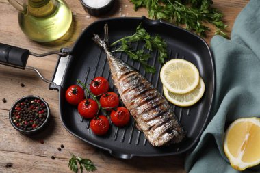 Lezzetli ızgara uskumrular, domatesler ve diğer ürünler ahşap masada, düz yerde.