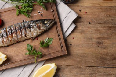 Lezzetli ızgara uskumru, maydanoz, baharatlar ve ahşap masada limon, düz yatak. Metin için boşluk