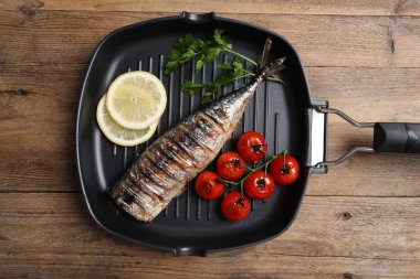 Lezzetli ızgara uskumru, domates, limon ve maydanoz ahşap masa, üst manzara