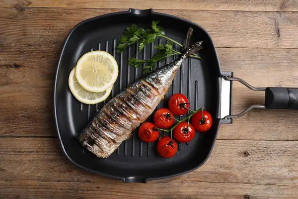 Lezzetli ızgara uskumru, domates, limon ve maydanoz ahşap masa, üst manzara