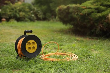 Uzatma kablosu dışarıda yeşil çimlerin üzerinde dönüyor.