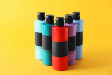 Turuncu arka planda farklı renklerde akrilik boyalar