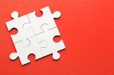 Kırmızı arka planda beyaz yapboz parçaları, üst manzara. Metin için boşluk