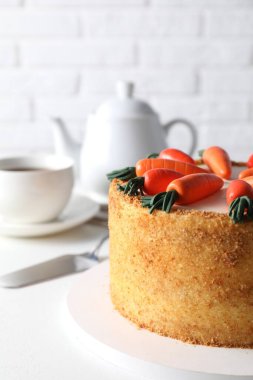 Lezzetli havuçlu kek ve sunucu beyaz masada, yakın plan.