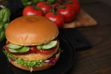 Ahşap masada nohut pirzolası ile nefis vegan burger, yakın plan.