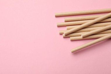 Pembe arka planda bambu pipetleri, üst manzara. Metin için boşluk