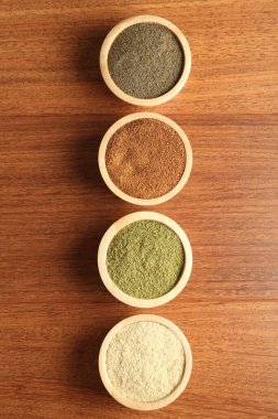 Tahta masadaki kaselerde farklı süper yiyecek tozları var.