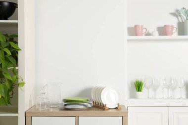 Beyaz duvarın yanında farklı mutfak gereçleri olan raf ünitesi