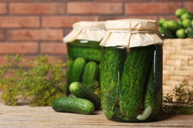 Kavanozda salatalık turşusu ve ahşap masada dereotu, yakın plan.