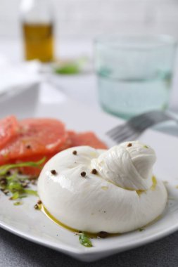 Lezzetli burrata peyniri, greyfurt ve baharatlar masada, yakın plan.